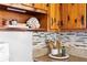 This kitchen boasts stylish décor, including natural elements atop stained knotty wood cabinetry and modern backsplash at 5713 23Rd S Ave, Gulfport, FL 33707