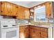 Kitchen with wood cabinets, granite countertops, mosaic backsplash, and white electric stove at 5713 23Rd S Ave, Gulfport, FL 33707