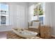 Cozy living space with a wicker chair, decorative bowl, and natural light filtering through sheer white curtains at 5713 23Rd S Ave, Gulfport, FL 33707