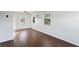 Bright living room with wood-look floors, white walls, large windows, and ceiling fan at 5713 23Rd S Ave, Gulfport, FL 33707