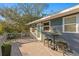 Outdoor deck features railing, a seating area with two stools, a table, flowers, and mature trees at 5713 23Rd S Ave, Gulfport, FL 33707