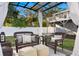 Covered patio seating area featuring wicker furniture, cushions, ottomans, and neutral rug at 5713 23Rd S Ave, Gulfport, FL 33707