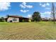 Expansive backyard featuring lush green grass and a glimpse of a screened lanai, ideal for outdoor enjoyment at 5817 Hidden Falls Ln, Apollo Beach, FL 33572