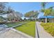 Bocce ball court with well-maintained green turf, seating area and lush landscaping under a clear, sunny sky at 5817 Hidden Falls Ln, Apollo Beach, FL 33572