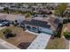 An aerial view of a single-story home with solar panels, showcasing the driveway and surrounding neighborhood at 663 Allegheny Dr, Sun City Center, FL 33573