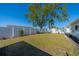 The grassy backyard features a white fence, mature landscaping, and is well maintained at 663 Allegheny Dr, Sun City Center, FL 33573