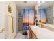Bathroom with a granite countertop, shower, and a sunset-themed shower curtain at 663 Allegheny Dr, Sun City Center, FL 33573