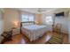 Bright bedroom with a large window, wooden floors, ceiling fan, and bedside tables at 663 Allegheny Dr, Sun City Center, FL 33573