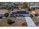 Aerial view of a charming single-story home with solar panels and a well-maintained lawn and landscaping at 663 Allegheny Dr, Sun City Center, FL 33573