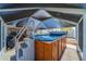 The screened in lanai features a hot tub with a wooden surround, stairs, and offers access to the home at 663 Allegheny Dr, Sun City Center, FL 33573