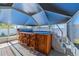This screened in lanai features a hot tub with a wooden surround, seating for four, and adjacent stairs at 663 Allegheny Dr, Sun City Center, FL 33573