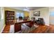 Well-lit office space with a large wooden desk, comfortable seating, built-in bookshelves, and hardwood floors at 663 Allegheny Dr, Sun City Center, FL 33573
