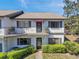 Two-story condo featuring a balcony, black shutters, and manicured landscaping at 6701 River Run Blvd, Weeki Wachee, FL 34607