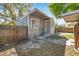 Side view of this gray house featuring a wooden fence and small staircase that leads to a side door entrance at 689 Paris S Ave, St Petersburg, FL 33701