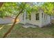 Back view of home featuring a back entrance, lush green grass, and a detached shed at 710 E Plymouth St, Tampa, FL 33603