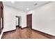 A bedroom with hardwood floors, white walls, and dark trim around a door and window at 710 E Plymouth St, Tampa, FL 33603
