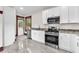 The updated kitchen features new stainless appliances, stylish marble flooring, and granite countertops at 710 E Plymouth St, Tampa, FL 33603