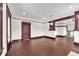 Large living room with dark hardwood floors, white walls, dark trim, and view to the kitchen at 710 E Plymouth St, Tampa, FL 33603