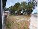 Spacious backyard with mature trees, a neighboring building, and an AC unit; ready for outdoor enjoyment at 710 Seminole, Clearwater, FL 33755