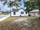 The backyard features a grassy area with trees and a glimpse of the street at 710 Seminole, Clearwater, FL 33755