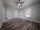 Open living room with wood-look flooring, a ceiling fan, updated windows, and light blue painted walls at 710 Seminole, Clearwater, FL 33755