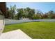 The backyard features a large grassy area, surrounded by a white fence with a shed in the distance at 818 S Main St, Brooksville, FL 34601