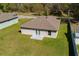 Expansive view of the backyard featuring a well-manicured lawn, patio area and fresh neutral colored siding at 818 S Main St, Brooksville, FL 34601