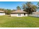 A well-maintained backyard featuring lush green grass, complemented by a charming house and a privacy fence at 818 S Main St, Brooksville, FL 34601
