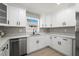 Well-lit kitchen features white cabinets with black hardware, a modern faucet, and stainless steel dishwasher at 818 S Main St, Brooksville, FL 34601