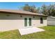 View of the patio with a white framed french doors in a home with light beige siding and a grassy yard at 818 S Main St, Brooksville, FL 34601