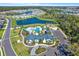 A beautiful aerial view of a community clubhouse with a pool, playground, and lakefront homes at 8337 Abalone Loop, Parrish, FL 34219