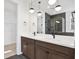 Beautiful bathroom with a double vanity, modern lighting, dark fixtures, and dark tile flooring at 8337 Abalone Loop, Parrish, FL 34219