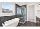 Bathroom with a freestanding tub and walk-in shower with dark tile surround and black fixtures at 8337 Abalone Loop, Parrish, FL 34219