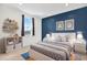 Staged bedroom featuring blue accent wall, modern furnishings, and plenty of natural light at 8337 Abalone Loop, Parrish, FL 34219