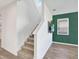 Bright hallway with a staircase, hardwood floors, and a flat screen TV at 8337 Abalone Loop, Parrish, FL 34219
