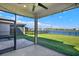 Screened-in patio with string lights overlooking a lush lawn and lake at 8337 Abalone Loop, Parrish, FL 34219