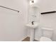 Stylish powder room featuring a pedestal sink, sleek black fixtures, and minimalist decor at 8337 Abalone Loop, Parrish, FL 34219