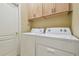 Bright laundry room featuring a side-by-side washer and dryer and wall mounted cabinets at 9117 Brindlewood Dr, Odessa, FL 33556