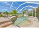 Inviting screened-in pool with lush landscaping and lounge chairs under a sunny sky at 9117 Brindlewood Dr, Odessa, FL 33556