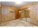 Bedroom featuring wood paneled walls, closet, and doorway to another room at 9611 Pine Ridge Ave, Riverview, FL 33578