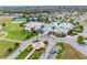 An aerial view of the community clubhouse featuring tennis courts, a pool with splash pad, and colorful facade at 9802 Carabiner Way, Land O Lakes, FL 34637