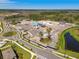 An aerial view of a future community clubhouse, pool and amenities under construction surrounded by native Florida foliage at 9802 Carabiner Way, Land O Lakes, FL 34637