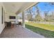 Covered back porch featuring outdoor furniture and a view of the white fenced yard at 9802 Carabiner Way, Land O Lakes, FL 34637