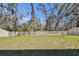 Spacious, grassy backyard with white privacy fence and mature trees at 9802 Carabiner Way, Land O Lakes, FL 34637