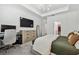 Modern bedroom with a sleek chandelier, desk area, large dresser, and neutral color palette at 9802 Carabiner Way, Land O Lakes, FL 34637