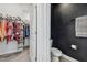 Organized walk-in closet with ample hanging space and shelving near a half bathroom with black accent wall at 9802 Carabiner Way, Land O Lakes, FL 34637