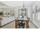 Bright dining area featuring a wooden table set, chandelier, and sliding glass doors to the outdoor space at 9802 Carabiner Way, Land O Lakes, FL 34637