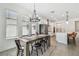Bright dining area featuring a wooden table set, chandelier, and a kitchen area at 9802 Carabiner Way, Land O Lakes, FL 34637