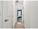 Hallway with wood-look flooring, leading to a room with a desk in front of a bright window at 9802 Carabiner Way, Land O Lakes, FL 34637