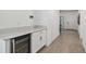 Hallway with wood-look floors and access to the entrance, featuring a beverage cooler at 9802 Carabiner Way, Land O Lakes, FL 34637